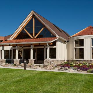 A modern residential house with a unique architectural design and landscaped surroundings.