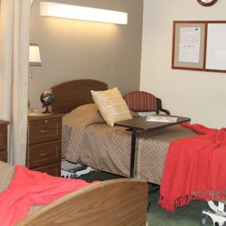 A cozy bedroom setup with two beds, warm blankets, and a bedside table.