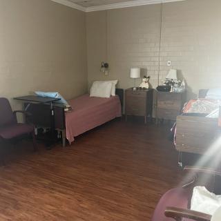 A hospital room with beds, chairs, and lamps arranged neatly.