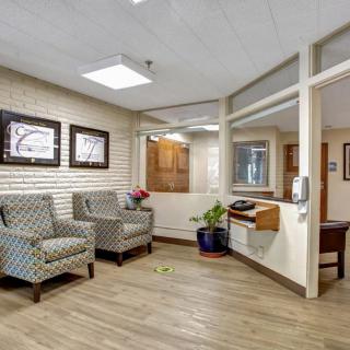 A modern office waiting area with comfortable seating and a reception desk.