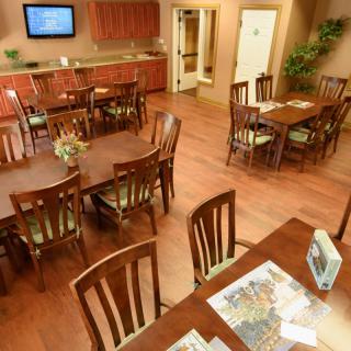 A cozy dining area with wooden tables and chairs, featuring a comfortable indoor atmosphere.