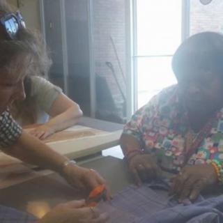 Two women collaborate on a sewing project indoors.