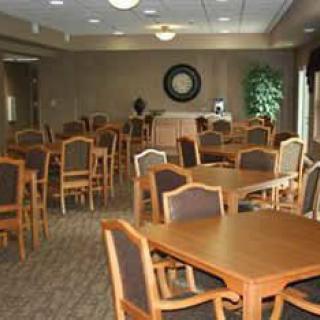An empty dining room with multiple tables and chairs arranged neatly.