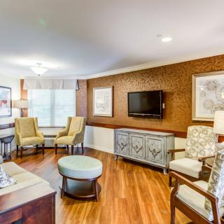 A modern living room with stylish furniture and a mounted television.