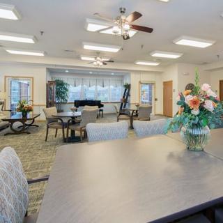 A well-lit interior space with tables, chairs, and floral decorations.