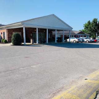 A view of a commercial building with a parking lot on a clear day.
