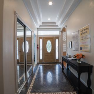 A well-lit foyer with elegant decor and a large mirror.