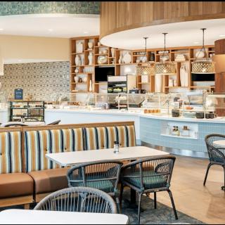 A modern cafe interior with stylish seating and a well-lit counter area.