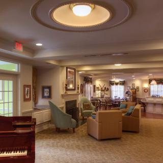 A cozy living room with comfortable seating and a piano.