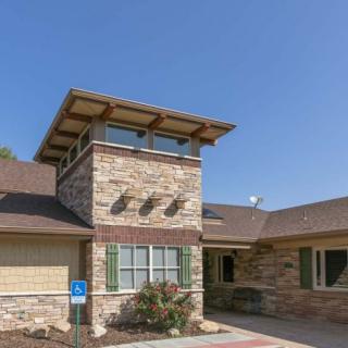 A modern residential building with a stone exterior and distinctive tower feature.