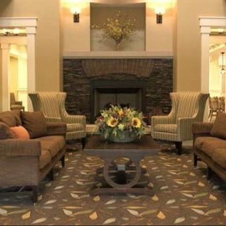A cozy living room with elegant furniture and a central fireplace.