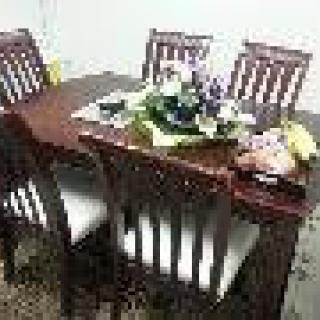 A dining table set with a flower arrangement centerpiece in a cozy home setting.