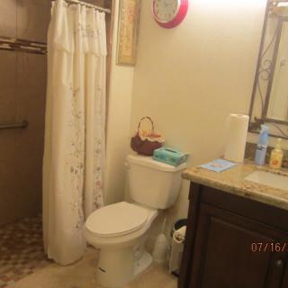 A tidy bathroom with a toilet, shower, and sink area.
