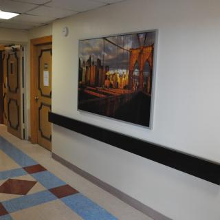 A hospital hallway featuring a colorful painting on the wall.