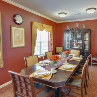 A warmly decorated dining room with a set table and elegant furnishings.