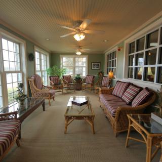 A cozy sunroom with ample seating and large windows allowing natural light to fill the space.