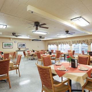 A spacious and well-lit dining area with neatly arranged tables and chairs.