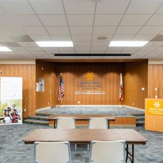 A conference room with a stage, podium, and seating arrangement.