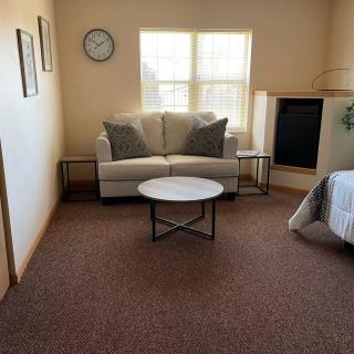A minimalist living room with a sofa, coffee table, and wall clock.