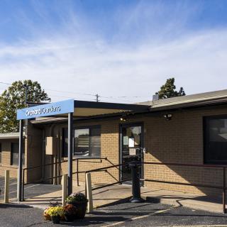 A clinic building with a visible entrance and clear skies overhead.