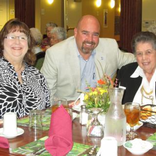 A group of three people enjoying a meal together at a restaurant.