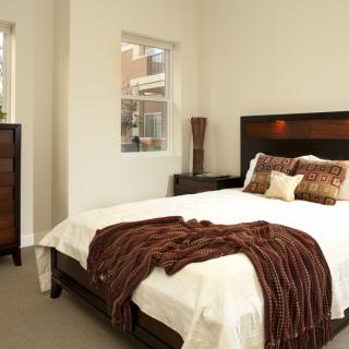 A cozy and elegantly decorated bedroom with a neatly made bed, soft pillows, and a plush blanket.