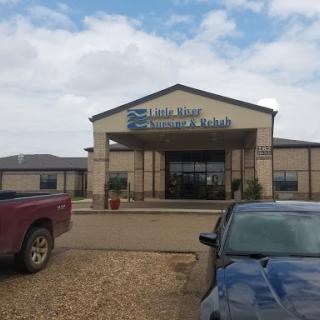 A commercial building with a welcoming entrance, set against a partly cloudy sky.