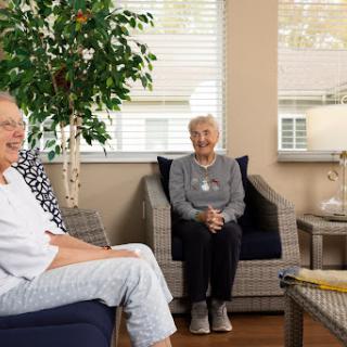 Two seniors enjoying a pleasant conversation in a cozy living room.