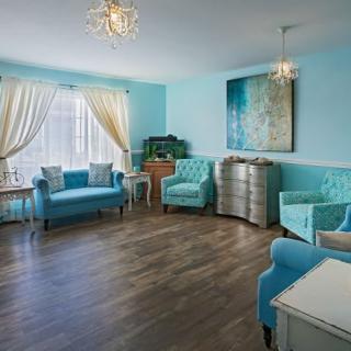 A stylish living room with blue walls, elegant furniture, and vibrant decor.