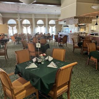 A spacious dining area featuring well-arranged tables and a welcoming atmosphere.