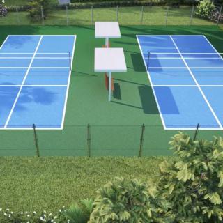 A pair of outdoor tennis courts surrounded by greenery.