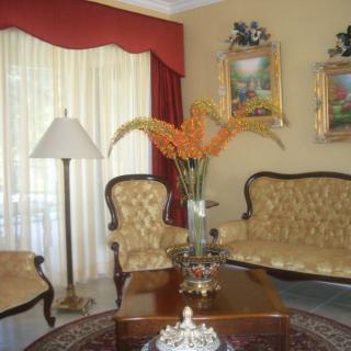 A traditionally decorated living room with elegant furniture and artwork.
