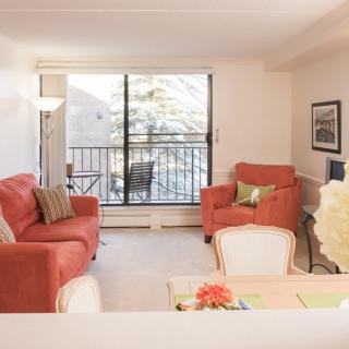Bright and cozy living room with red sofas and a view of the balcony.