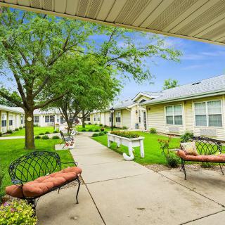 A picturesque courtyard with benches, trees, and surrounding buildings.