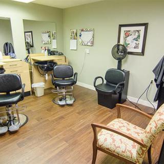 A cozy salon with barber chairs, mirrors, and a waiting area.