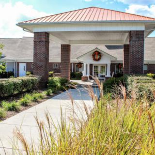 The inviting entrance of a community center, surrounded by well-maintained landscaping.