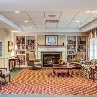 A cozy living room with a fireplace surrounded by bookshelves and comfortable seating.
