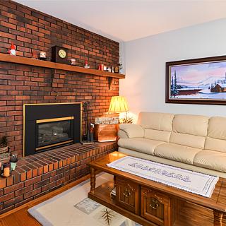 Cozy living room with a brick fireplace and comfortable seating.