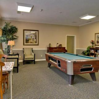 A cozy game room with a pool table and comfortable seating.