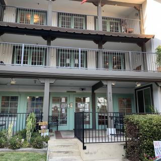 A multi-story residential building with balconies and a front porch.