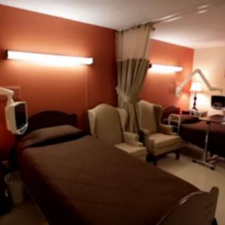 A hospital room with beds and privacy curtains.