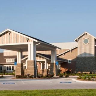 A modern building with a prominent entrance and outdoor landscaping.