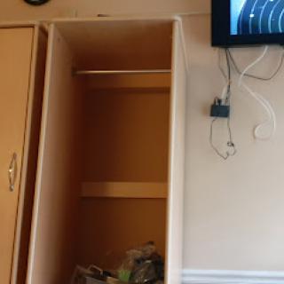 An empty closet beside a wall-mounted television.