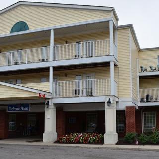 A multi-story hotel building with balconies and a covered entrance.