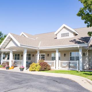 A suburban residential building with a front porch and landscaped garden.