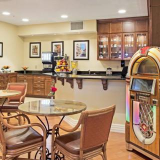 A cozy cafe with a jukebox, seating area, and counter.