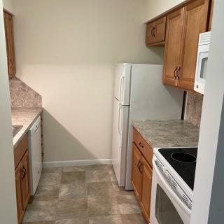 A compact kitchen featuring wooden cabinets and standard appliances.