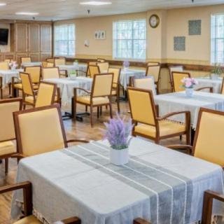 A neatly arranged dining room with tables and chairs, featuring simple decor.