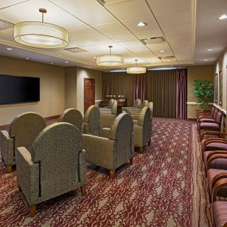 A well-arranged conference room with comfortable seating and a large television.