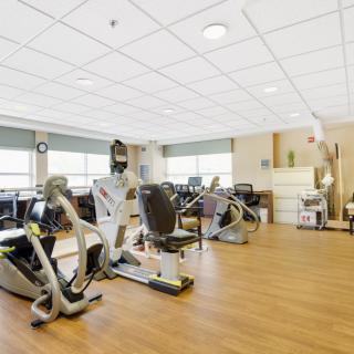 A spacious gym with various exercise machines and stationary bikes.